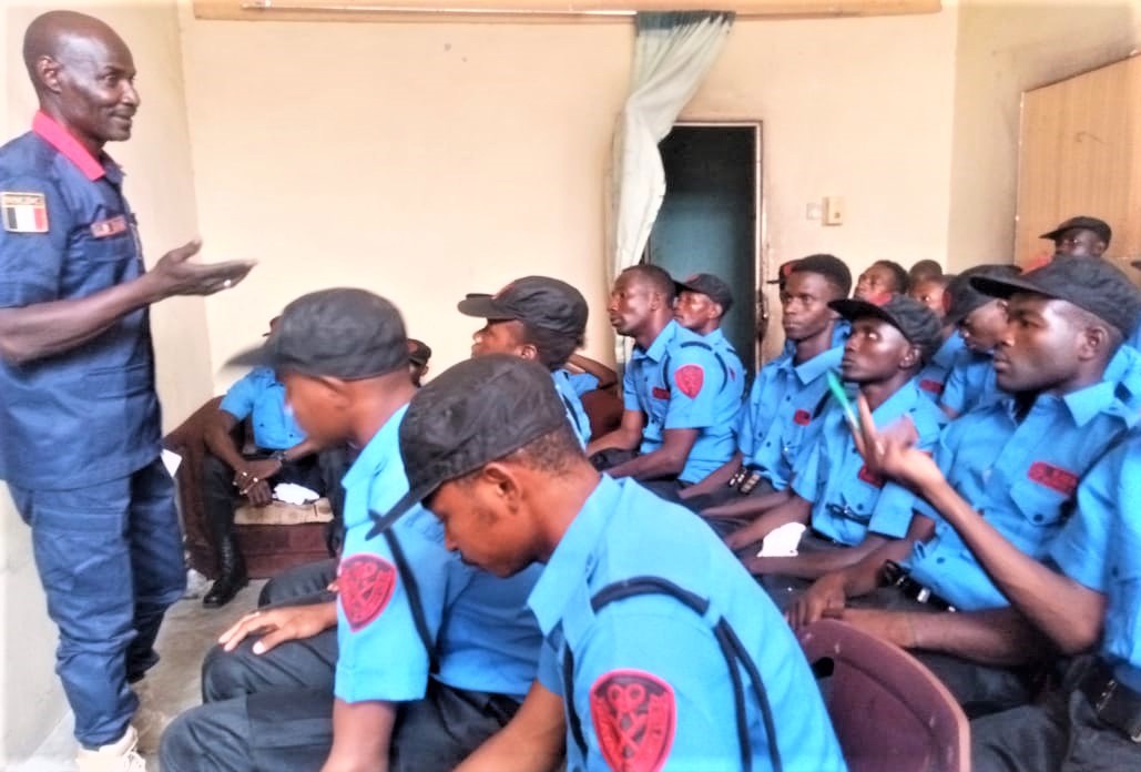Senior instructor speaking with security officers during a classroom session